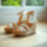 Elegant white strappy wedge sandals on a wooden surface