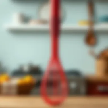 Close-up of textured red silicone whisk with a blurred kitchen background